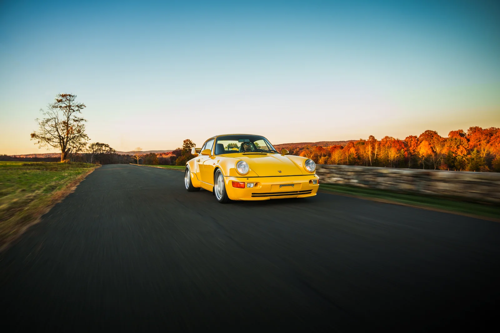 Yellow Porsche 911 Turbo on an autumn road